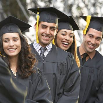 Graduate students standing in a row, outdoors