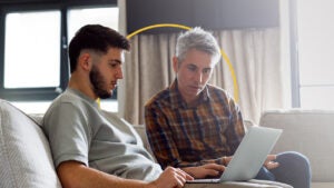 A man helps his college-aged son complete the FAFSA