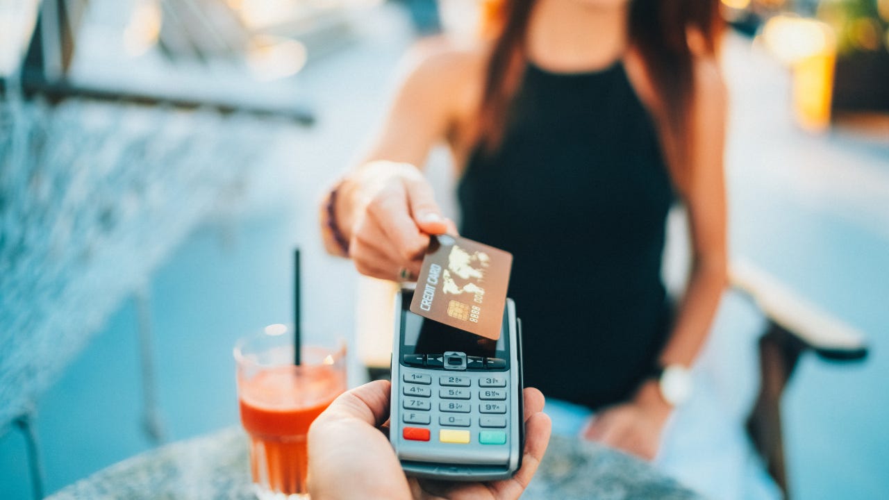 Woman in a cafe using a credit card