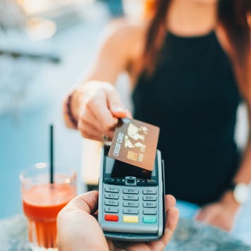 Woman in a cafe using a credit card