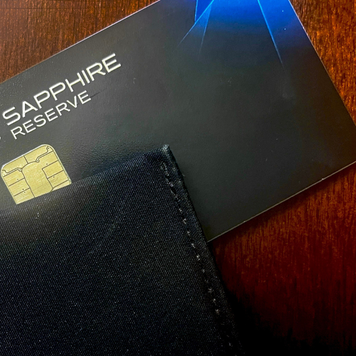 A black wallet sits on top of a sapphire reserve credit card.