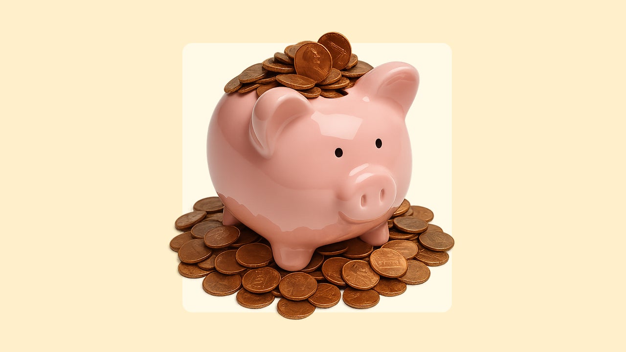 A fat pink piggy bank stuffed full of pennies sitting on top of a pile of pennies.