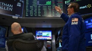 NYSE stock exchange traders looking at the list of index prices including the S&P 500