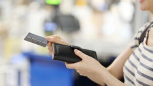 A woman holding a wallet and a credit card