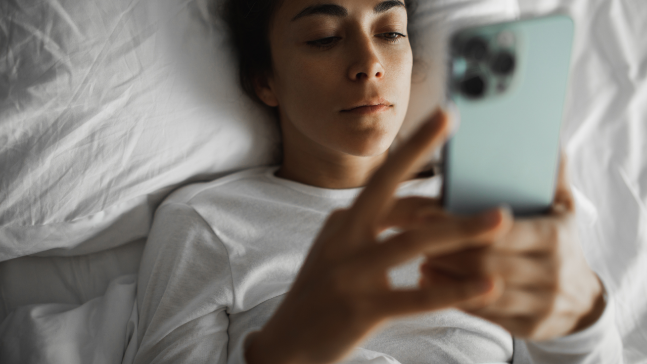 Woman looking at her phone in bed.