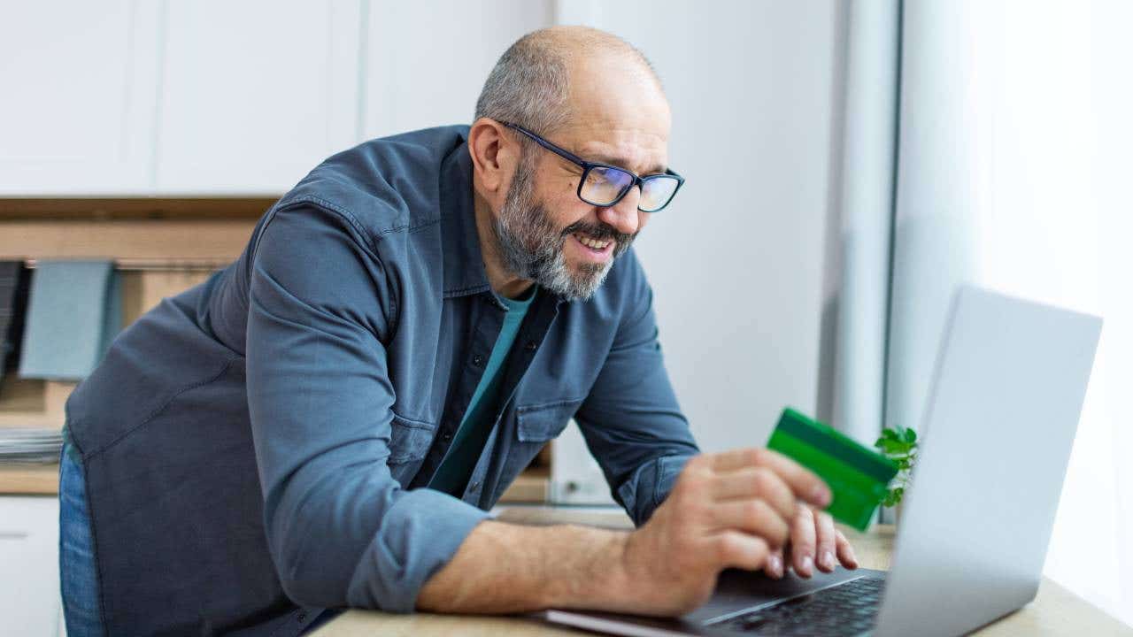 Man using laptop for online shopping, paying with credit card