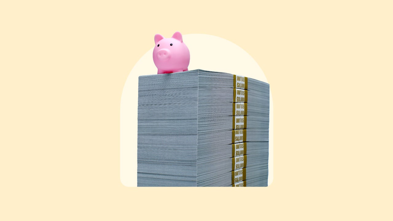 A piggy bank atop a stack of cash