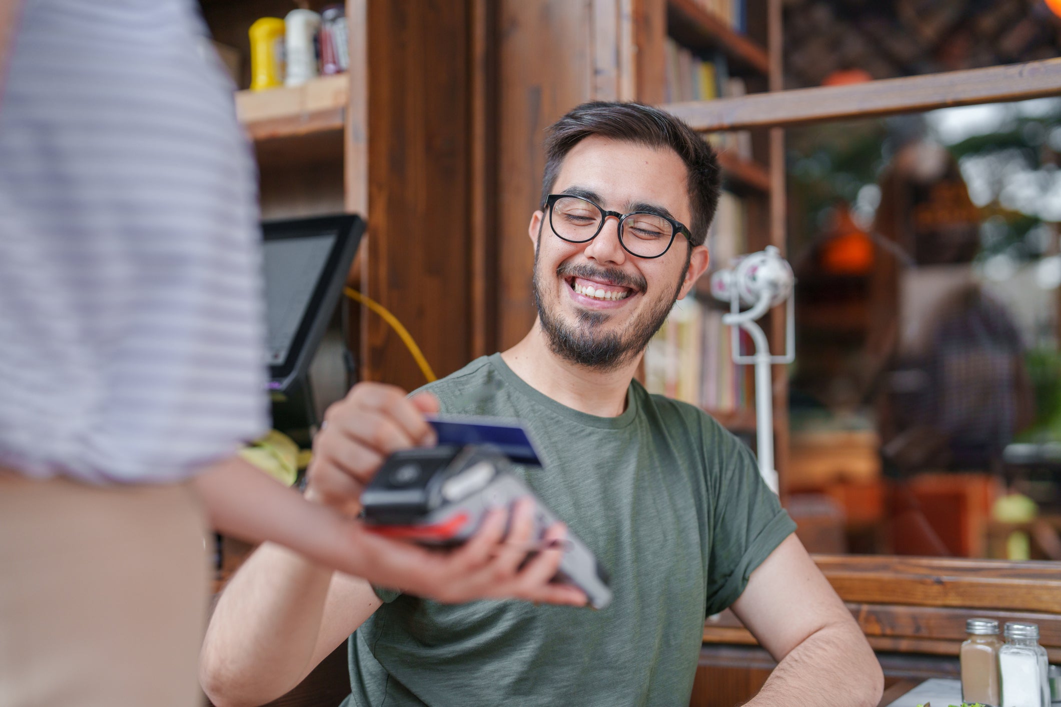 The man paying the restaurant bill with a contactless credit card
