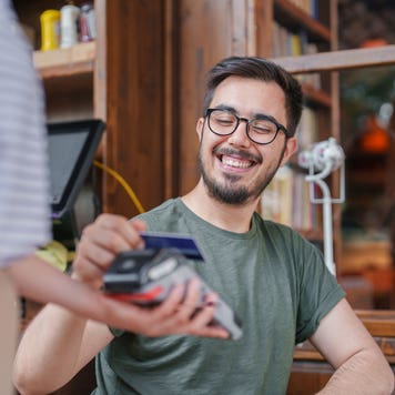 The man paying the restaurant bill with a contactless credit card