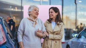 design image featuring an older women walking hand in hand with another woman