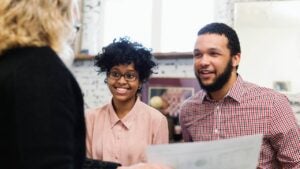 A young couple talk with a financial advisor about their retirement plan.