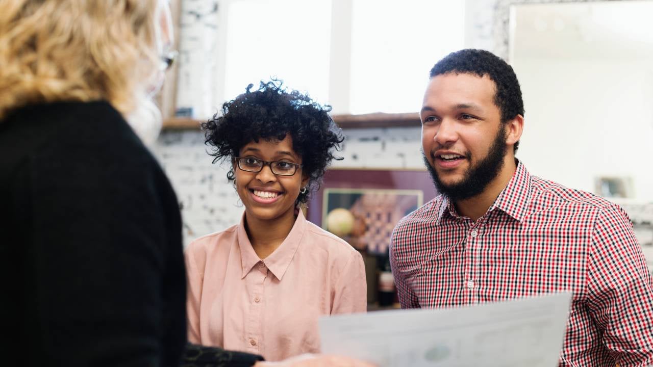 A young couple talk with a financial advisor about their retirement plan.