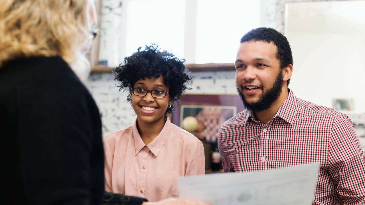A young couple talk with a financial advisor about their retirement plan.