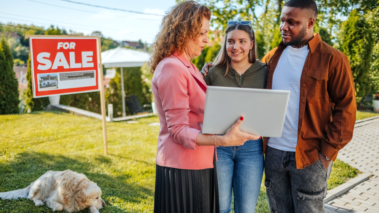 Real estate agent discussing the costs of buying a house with a young couple.