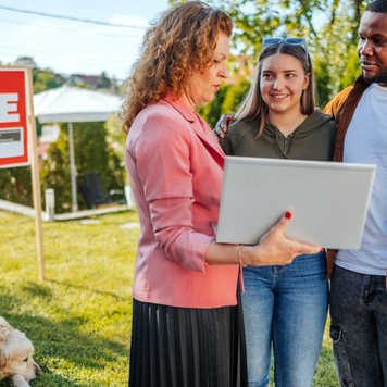 Real estate agent discussing the costs of buying a house with a young couple.