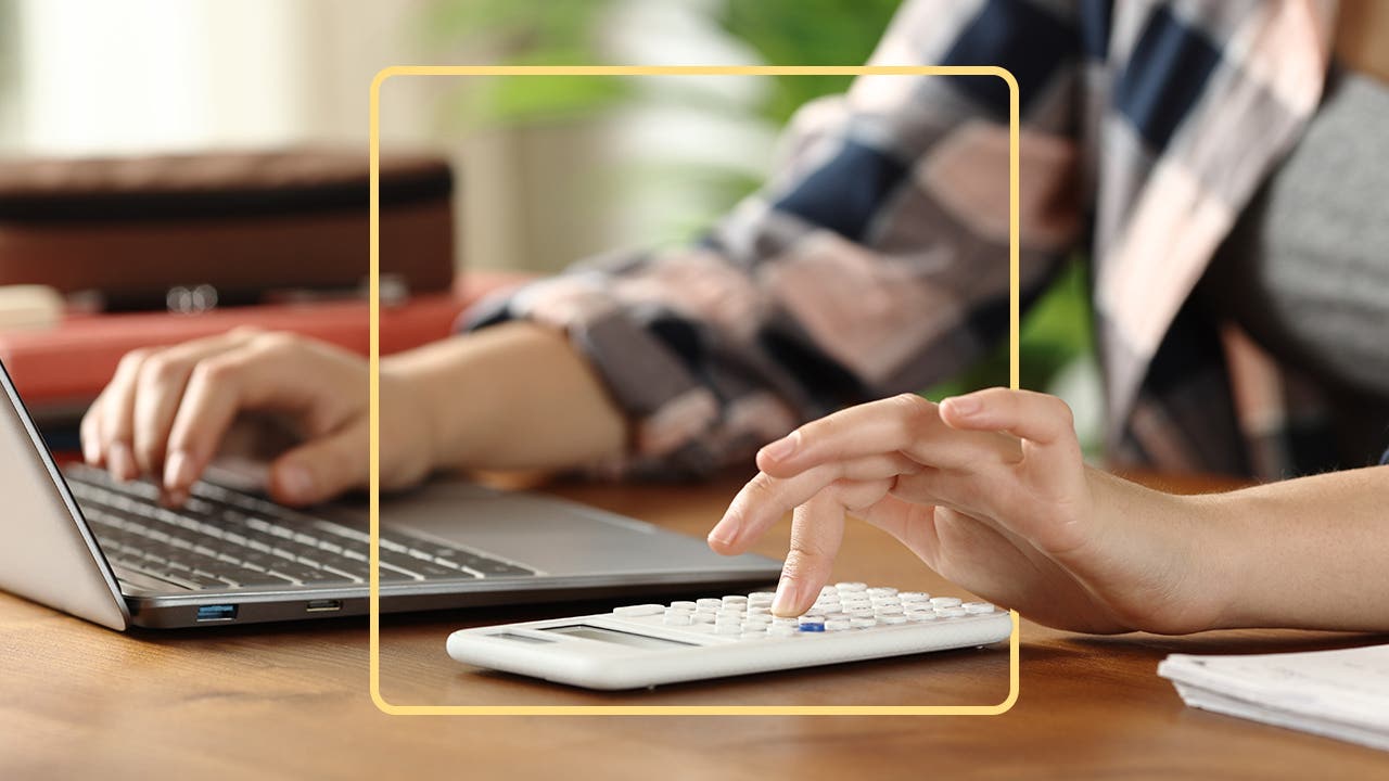 A person uses a calculator and tablet.