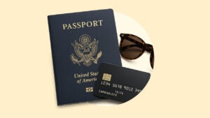 A passport, credit card, and sunglasses surrounded by a yellow background.