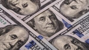 Fragments of five $100 bills showing Benjamin Franklin's face five times in a diamond shape.