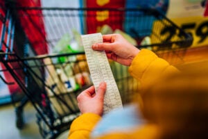 Woman checking the bill when paying at a supermarket.