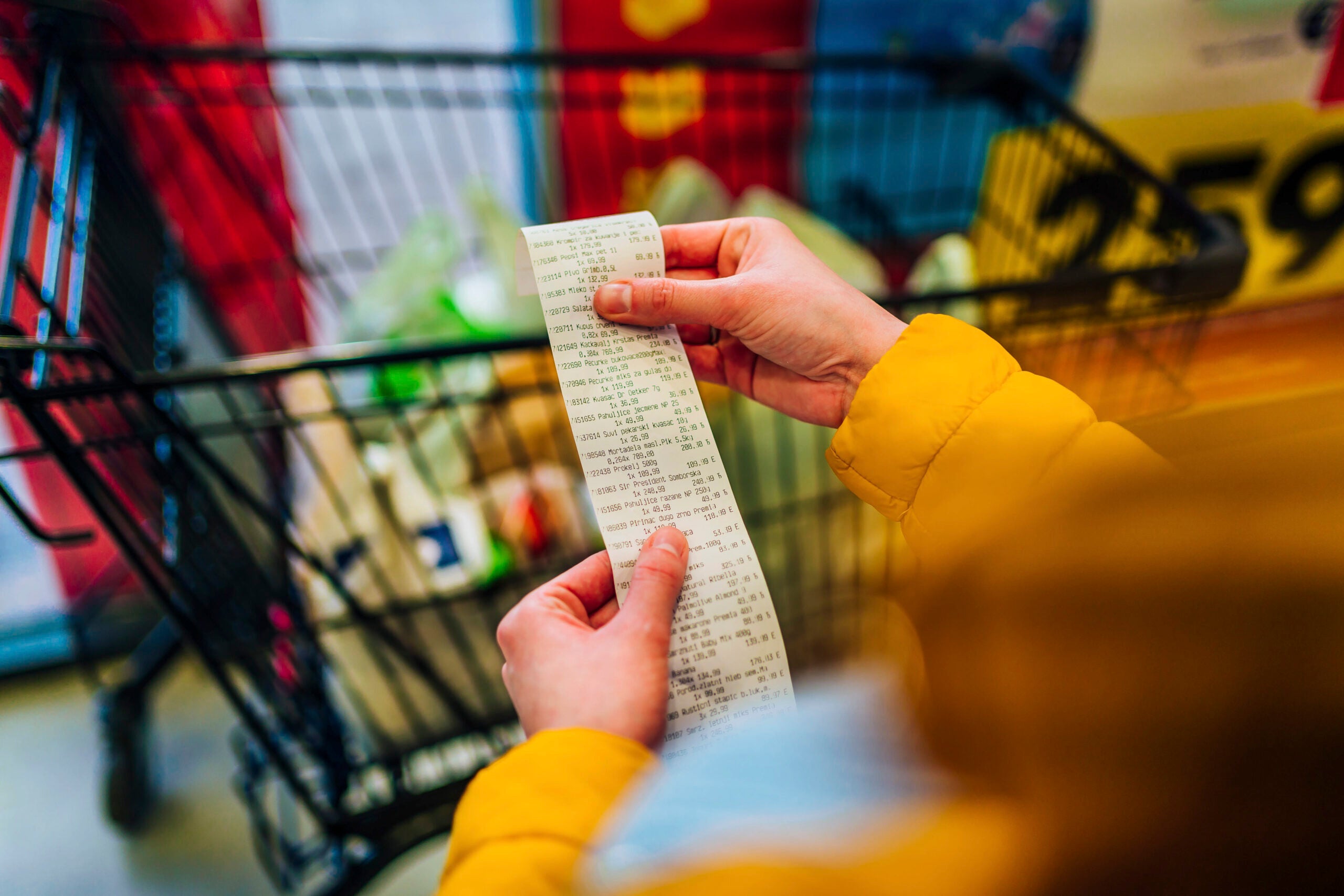 Woman checking the bill when paying at a supermarket.