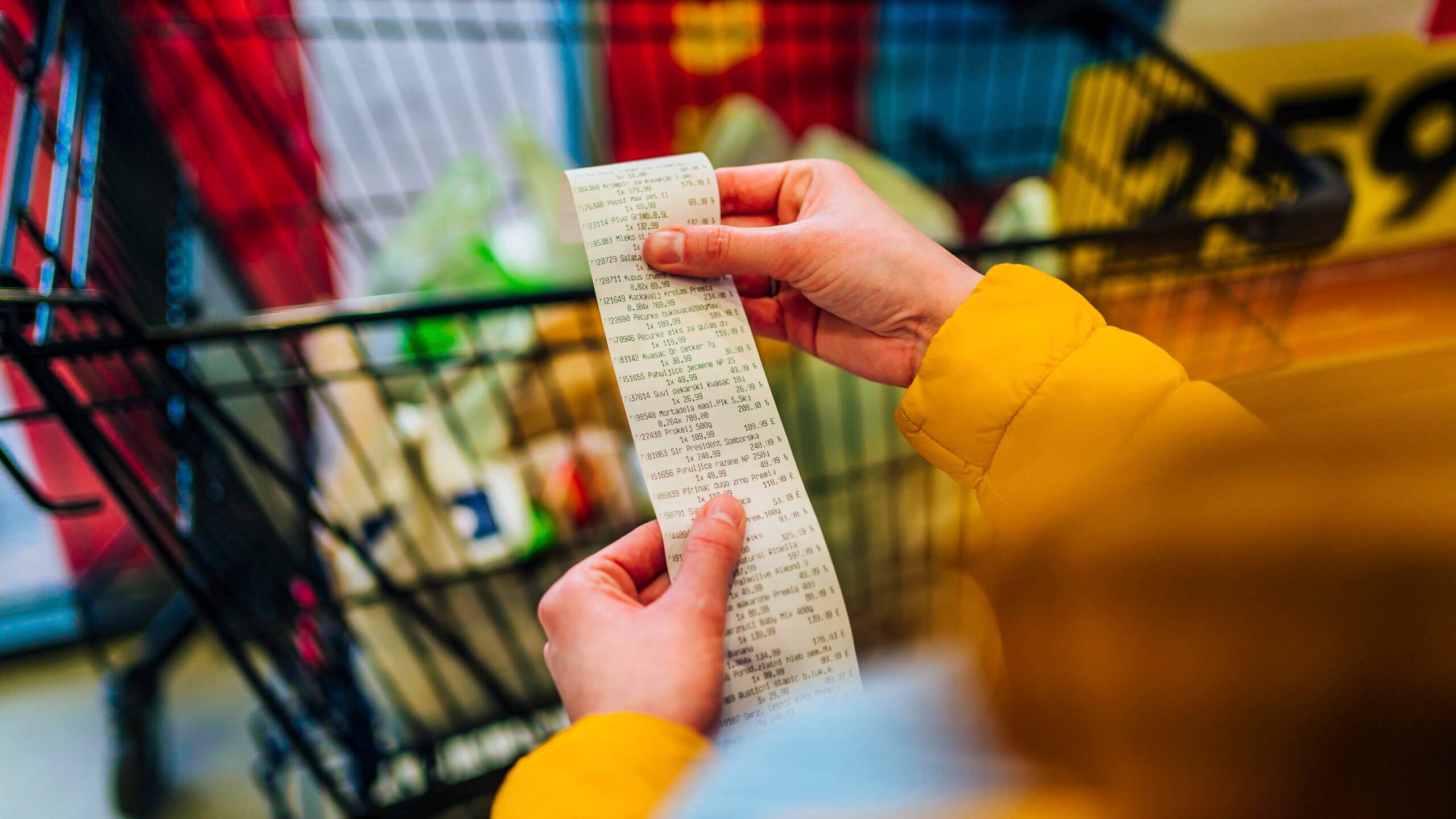 Woman checking the bill when paying at a supermarket.