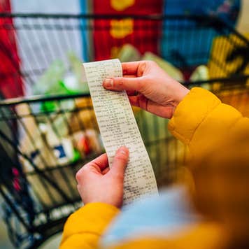 Woman checking the bill when paying at a supermarket.