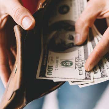 person opening wallet with cash inside