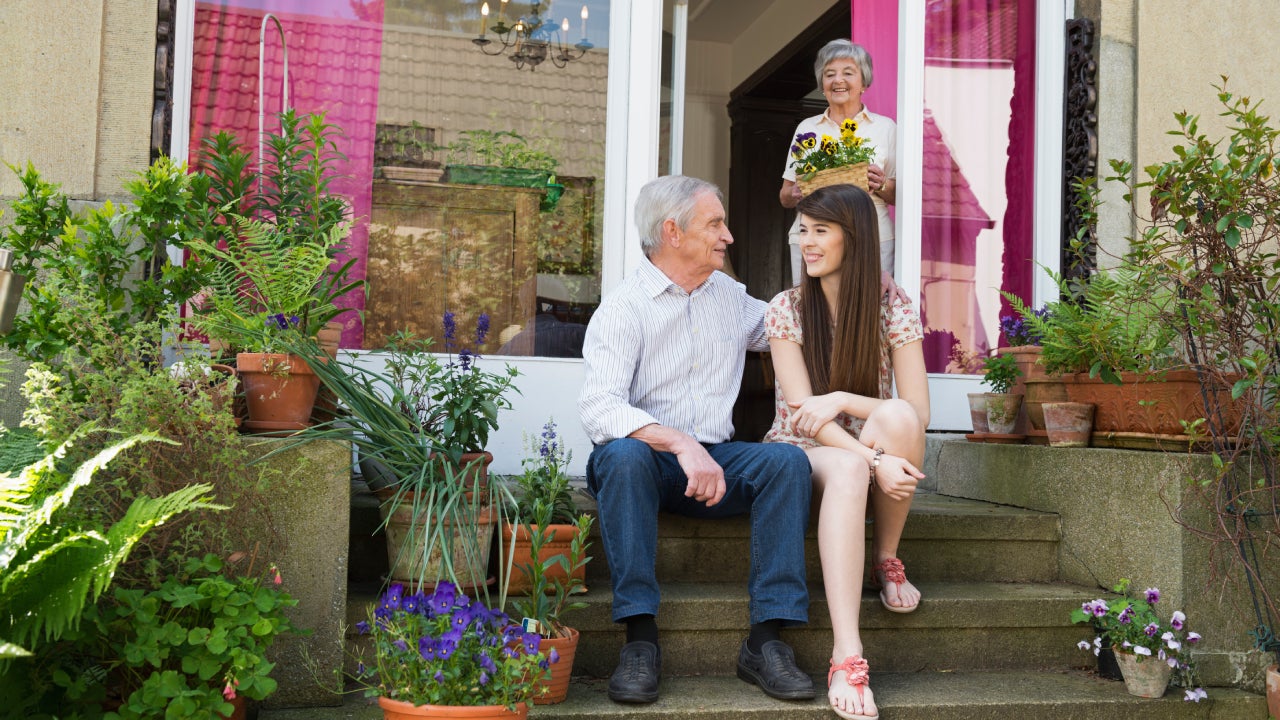 Young woman and grandparents on back door steps