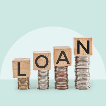 Scrabble tiles perched atop coins spelling out the word LOAN.