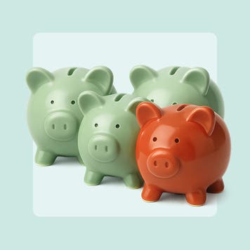 Image of four piggy banks of different sizes grouped together. Three are a light green color and the one in front is brick red.
