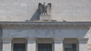 Close-up photo of the front of the Federal Reserve in Washington, DC, with the name "Federal Reserve" below the bust of the eagle.