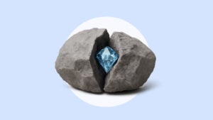 A diamond sits inside of a split rock on a blue background.