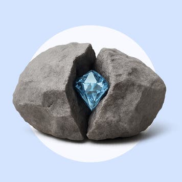 A diamond sits inside of a split rock on a blue background.