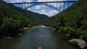 A large bridge over a body of water with boaters.