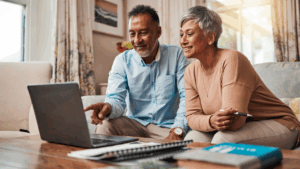 Mature couple sitting at a laptop, planning their finances.