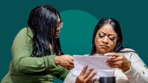 two women looking at an envelope, concerned