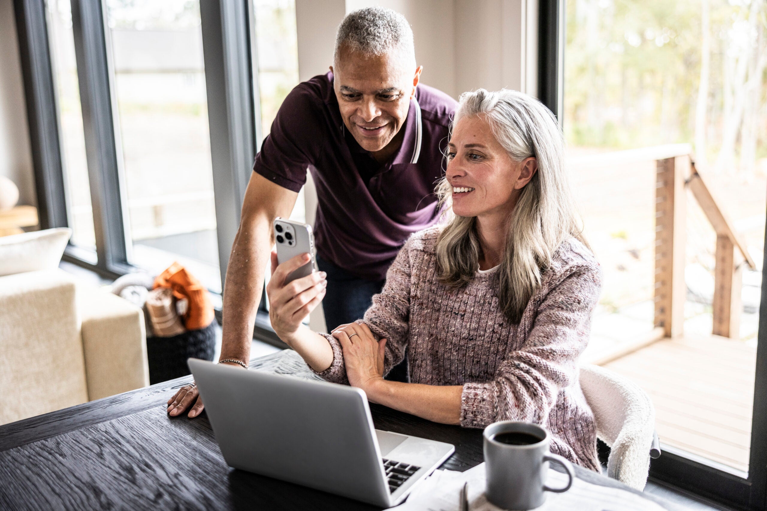 Couple looking at a laptop and a smartphone.