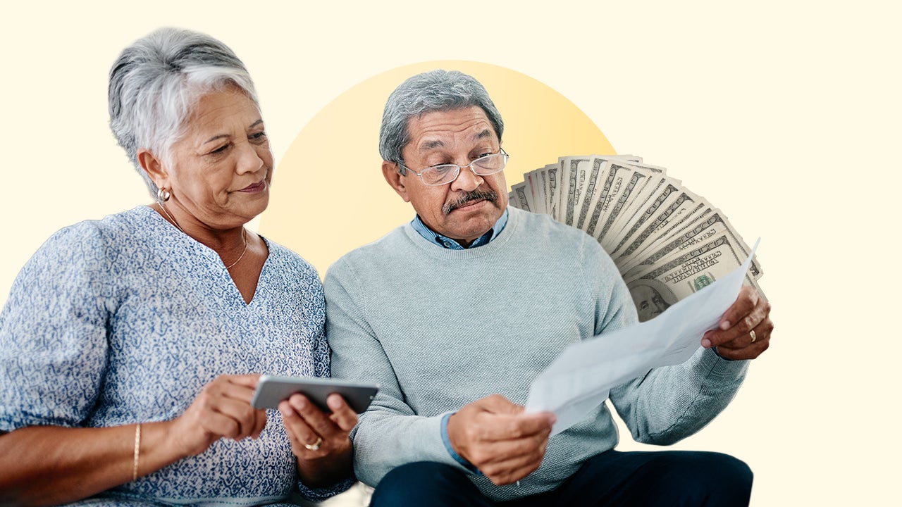 Two people looking at a large piece of paper with several $100 bills fanned out in the background.