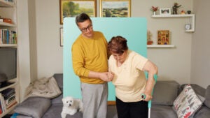 Image of a man supporting a woman who is using a forearm crutch.