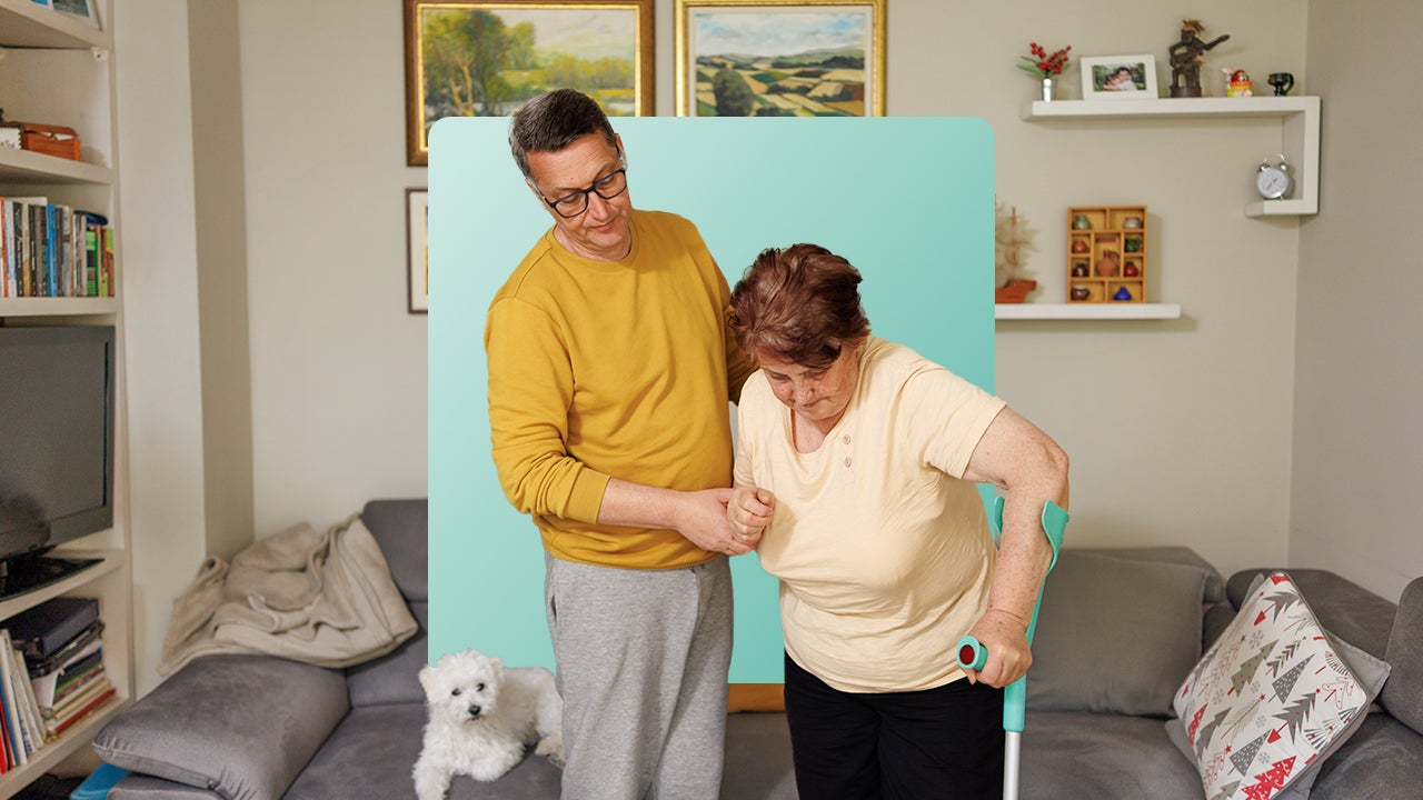 Image of a man supporting a woman who is using a forearm crutch.