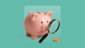 A piggy bank looks through a magnifying glass at a coin.