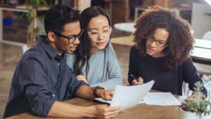 A couple looks over paperwork with a financial advisor.