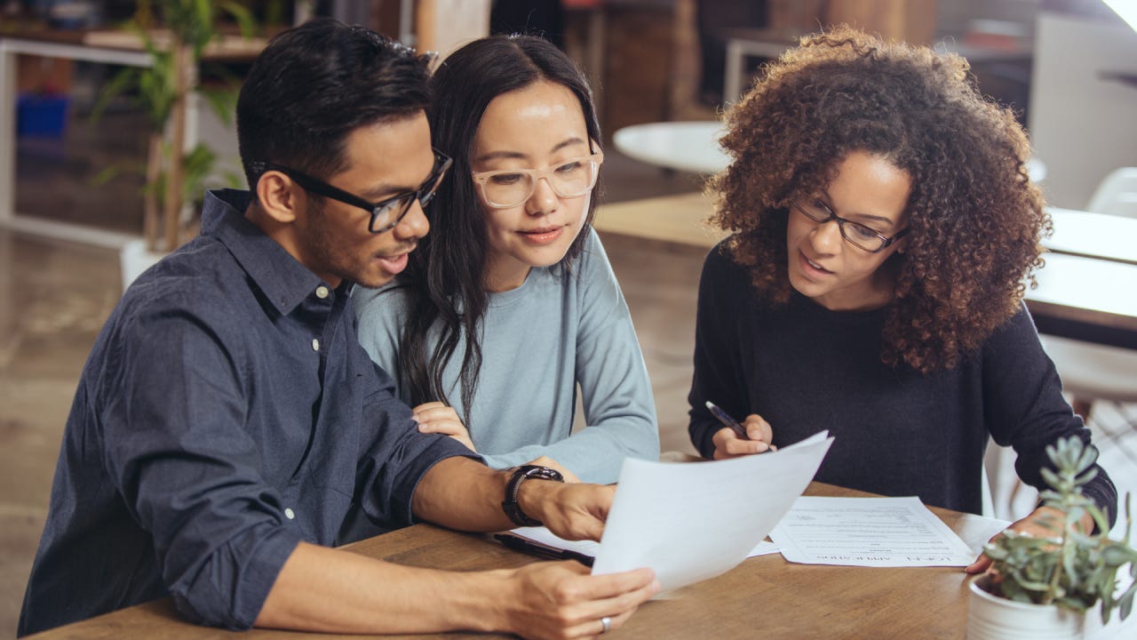 A couple looks over paperwork with a financial advisor.