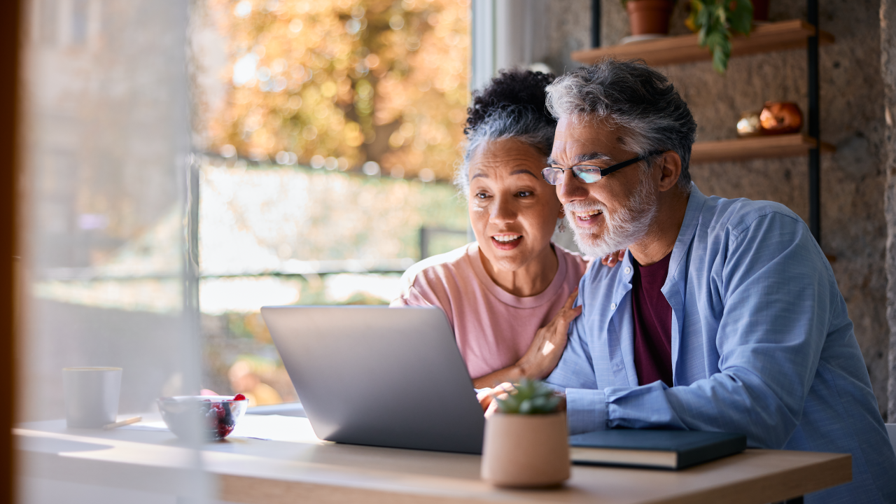 Older couple doing their finances on their laptop at home.