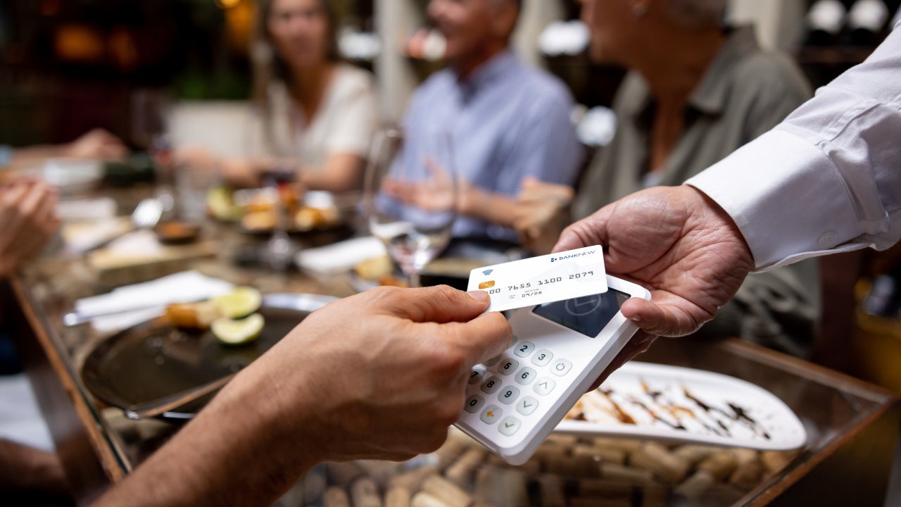 Close-up on a man making a contactless payment at a restaurant using his credit card