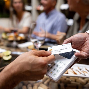 Close-up on a man making a contactless payment at a restaurant using his credit card