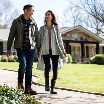 Couple walking in front of a home.