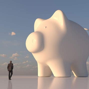 Computer artwork of a businessman looking at giant, white piggy bank.