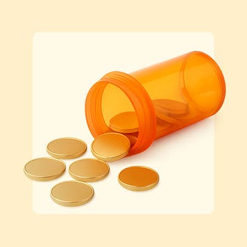 Coins spill out of a prescription pill container