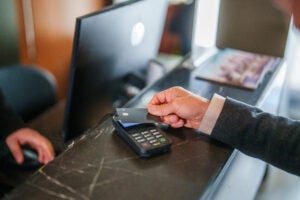 Man pays at hotel reception with a credit card